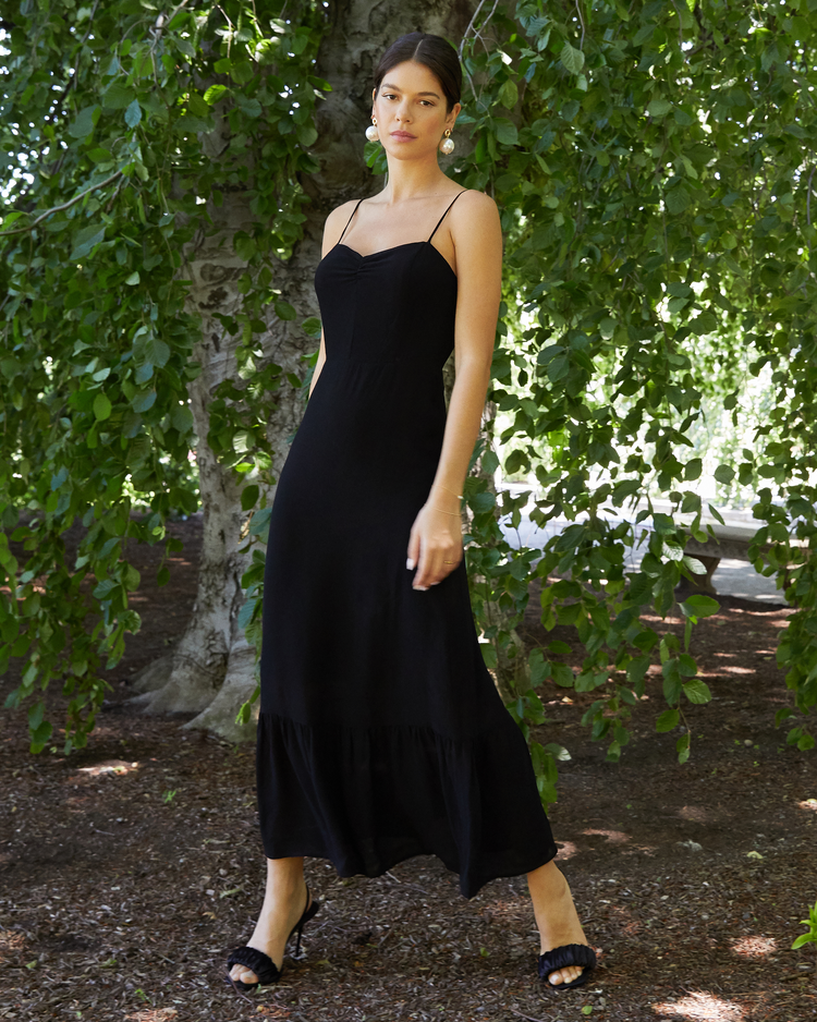 First image of Evelyn Dress, a black bridesmaid maxi-length dress with ruched bust detail, sweetheart neckline, tiered skirt, back smocking, adjustable straps, back zipper, and lining