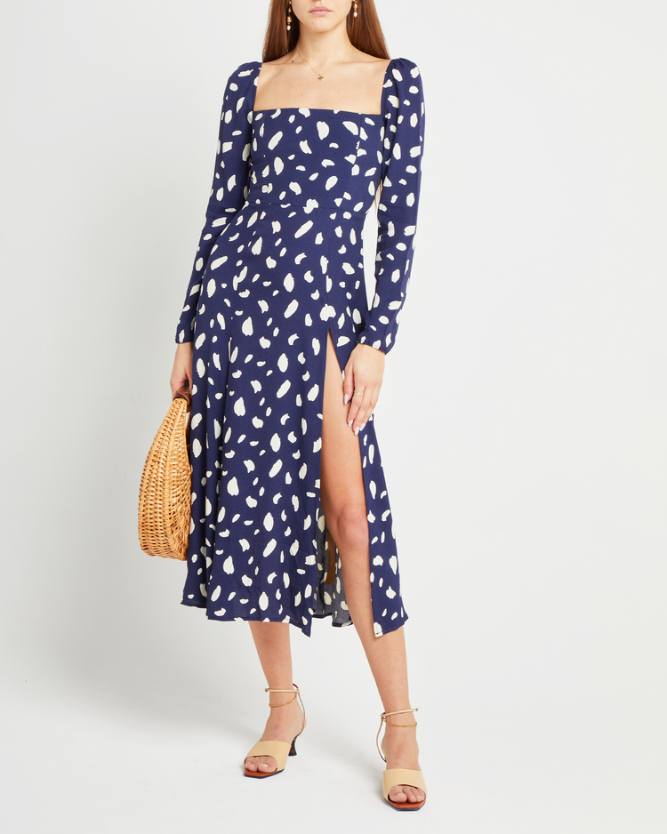 First image of Lenon Dress, a midi dress, side skirt slit, long sleeves, square neckline, blue material with white irregular dots