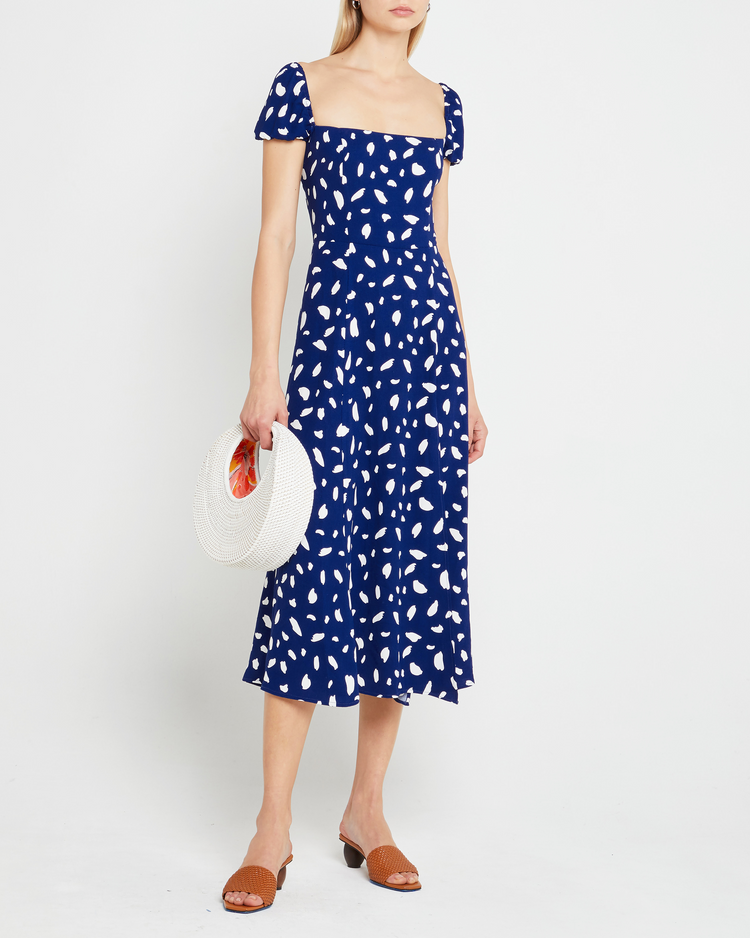 Third image of Cyra Dress, a blue midi dress, white polka dot, cap sleeves, side slit, square neckline
