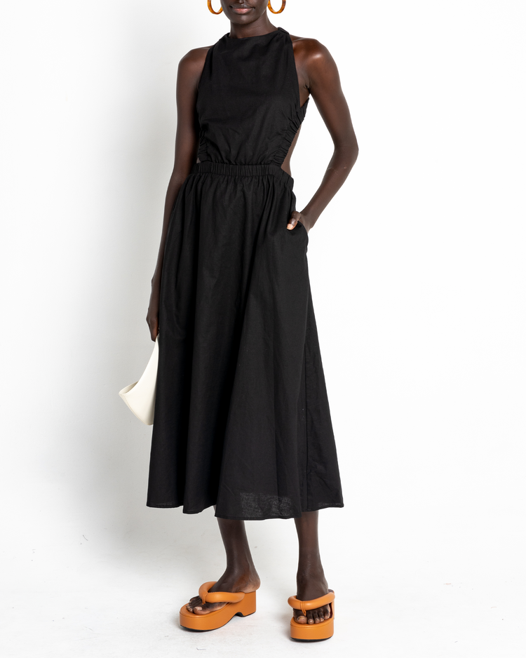 Second image of Bandage Dress, a black midi dress, open back, elastic straps, high neckline