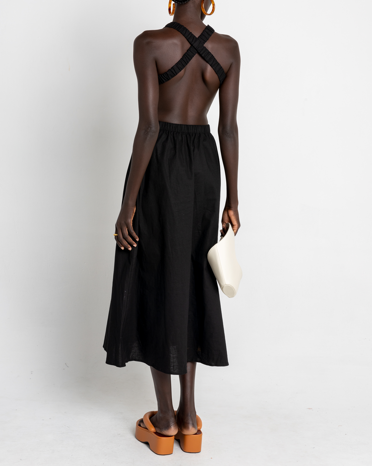 First image of Bandage Dress, a black midi dress, open back, elastic straps, high neckline