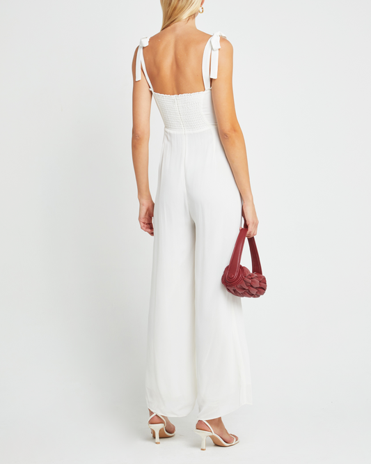 Second image of Blair Jumpsuit, a white jumpsuit with straight-leg lined pants, adjustable tie straps, cup detail, neckline ruffles, and a back zipper