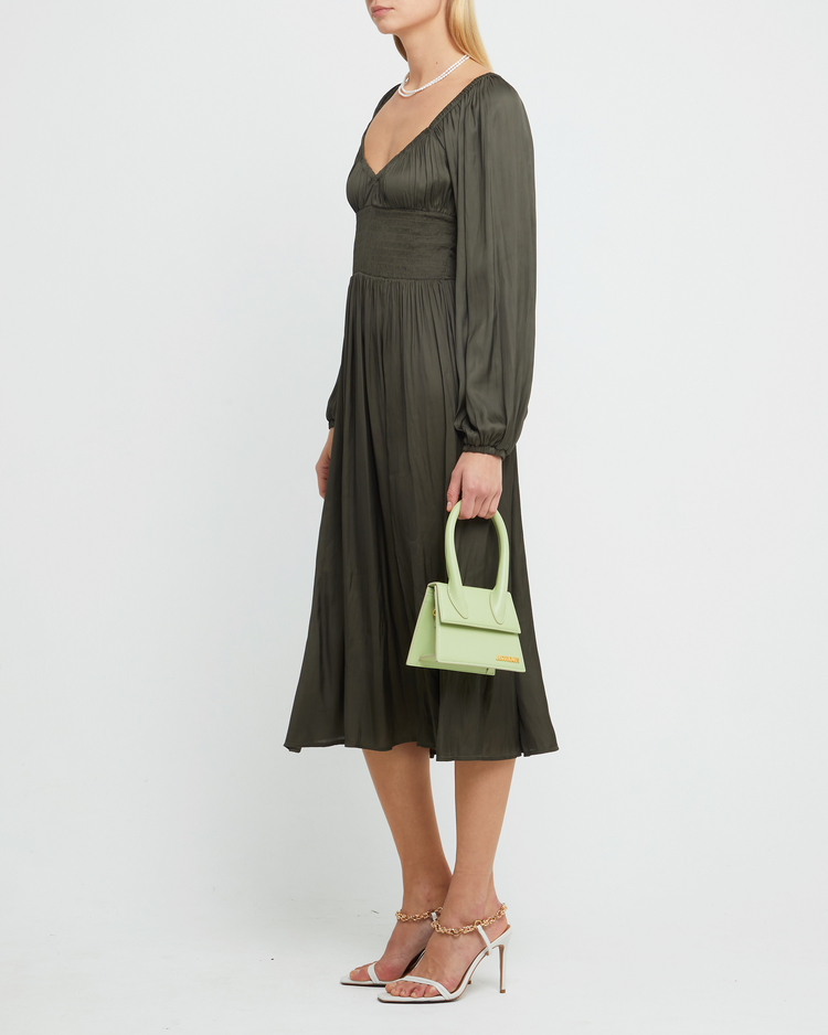 Third image of Nala Dress, a green midi dress, silky, smooth, thin, pleated, smocked, V-neck, side slit