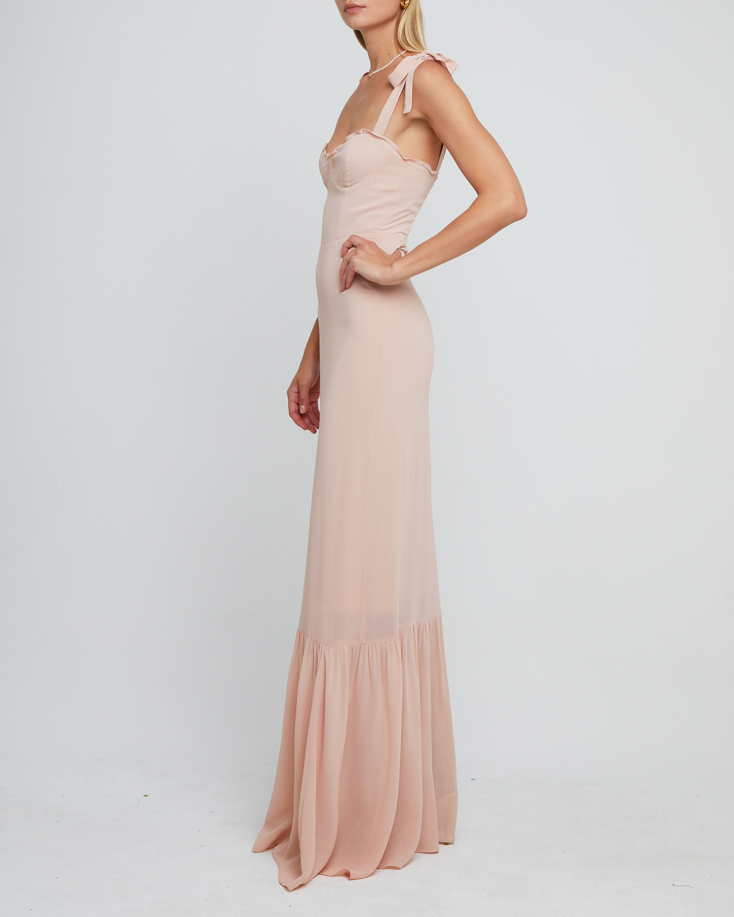 Third image of La Rue Dress, a pink floor-length bridesmaid dress with adjustable tie straps, cup detail, neckline ruffles, tiered skirt, lining, back smocking and back zipper
