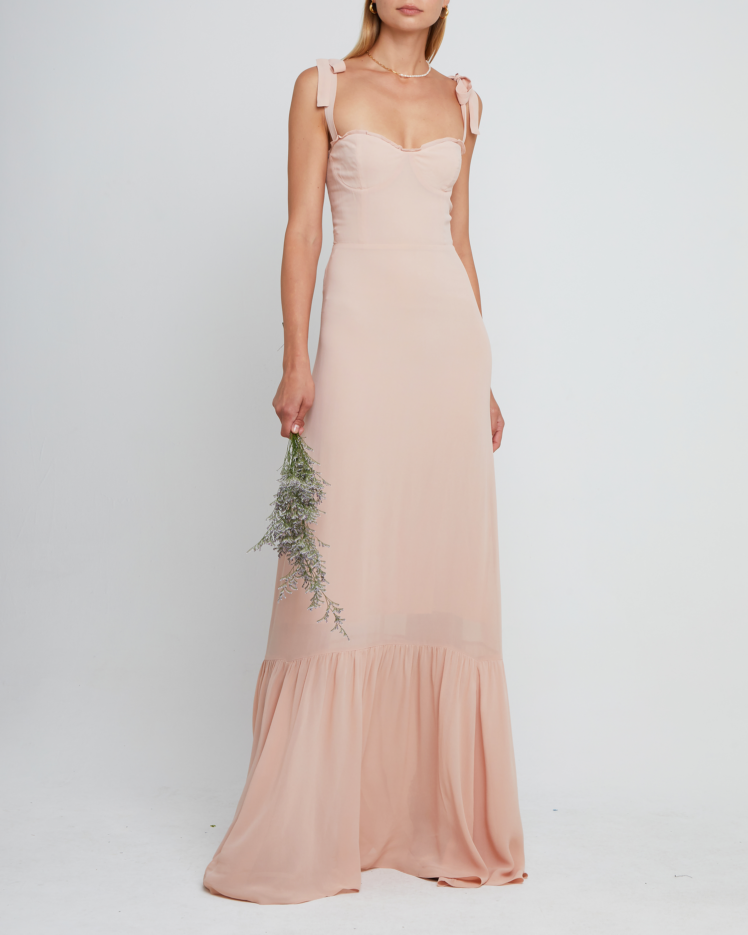 First image of La Rue Dress, a pink floor-length bridesmaid dress with adjustable tie straps, cup detail, neckline ruffles, tiered skirt, lining, back smocking and back zipper