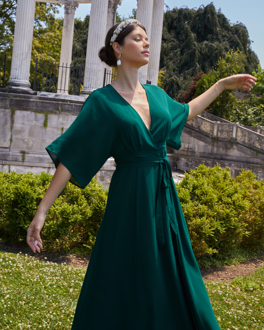 First image of Artie Dress, a green long maxi wrap style bridesmaid dress with flutter sleeves, v-neckline, adjustable waist tie, lining, and dart detail on bodice